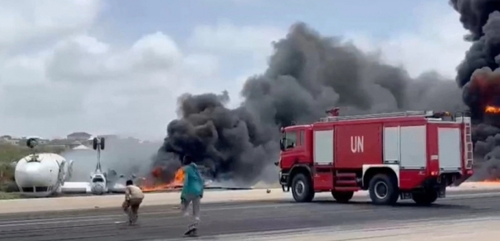 Smoke billows from a plane that flipped over after crash-landing, in Mogadishu, Somalia, July 18, 2022